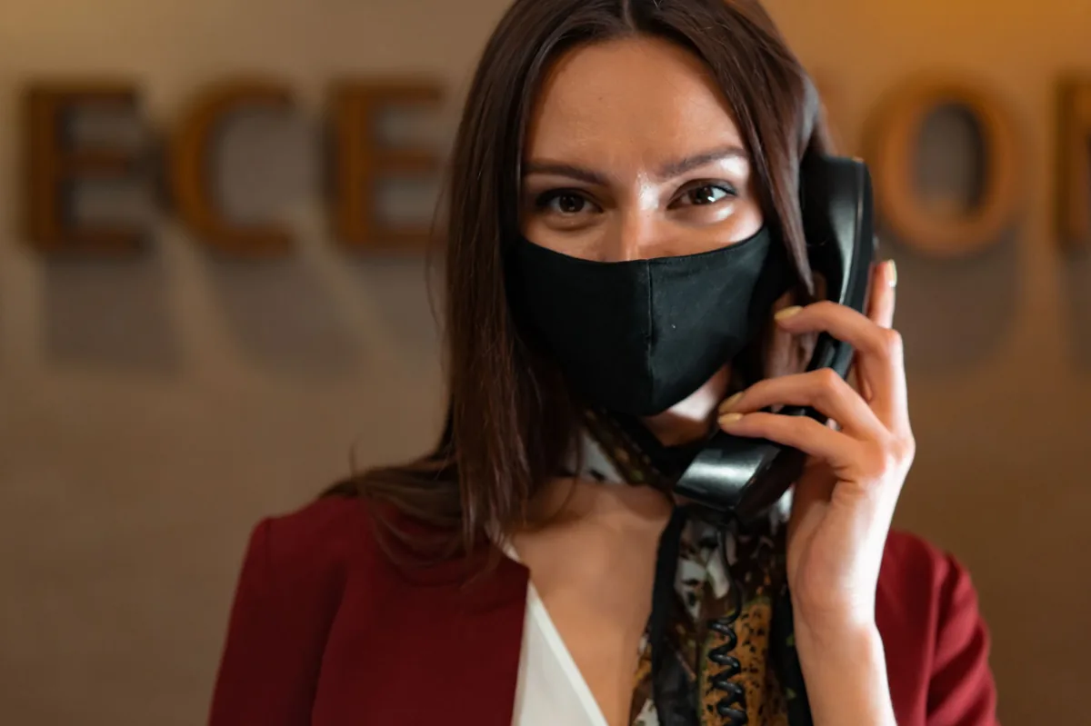 Receptionist at a small business front desk answering an incoming phone call