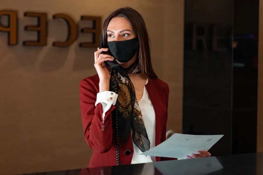Receptionist at a small business front desk answering an incoming phone call