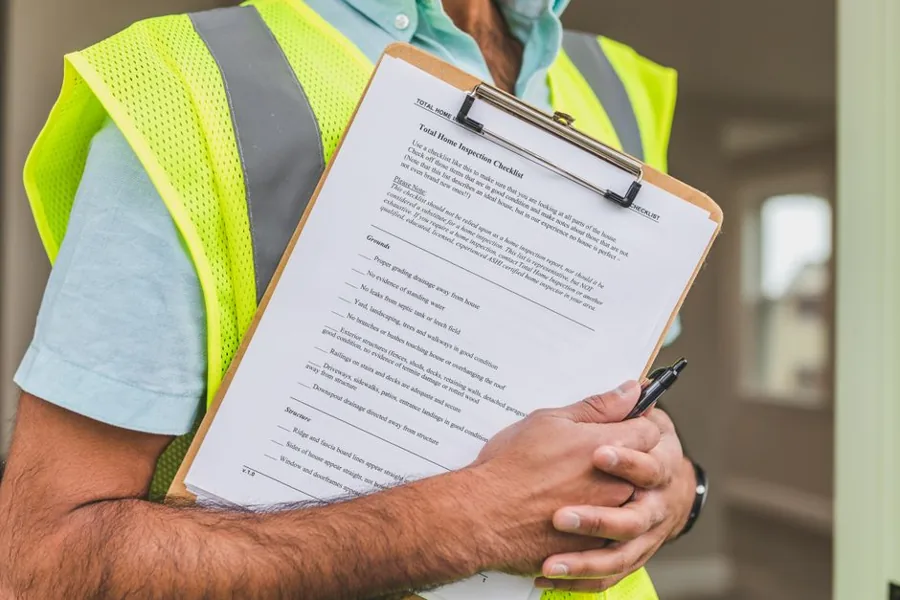 A service technician shaking hands with a homeowner at the door, the moment a lead becomes a booked job and a real cost per booked job