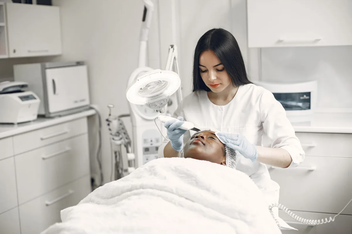 Aesthetician treating a client in a modern med spa treatment room