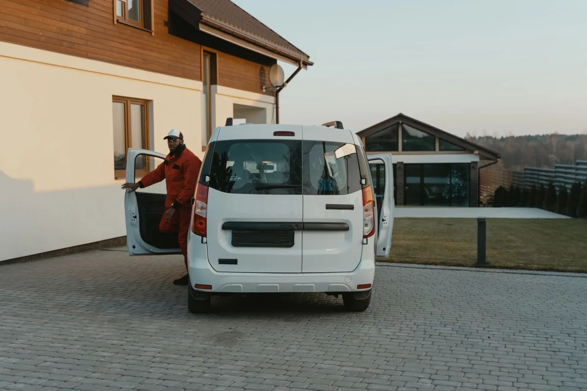 A uniformed local service technician greeting a homeowner at the front door, the kind of booked job a top Google Maps ranking produces.