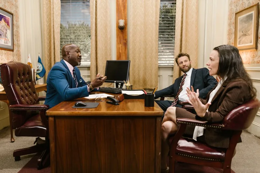An attorney shaking hands with a prospective client across a desk in a law firm office