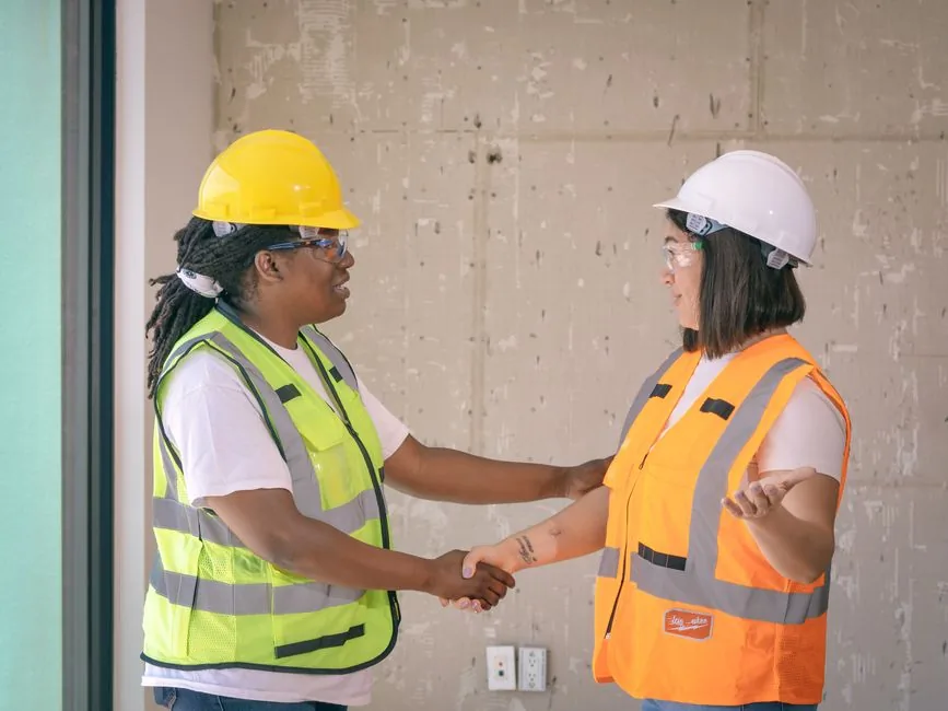 A local service contractor shaking hands with a homeowner at the front door, illustrating marketing ROI for local business at the booked-job moment.