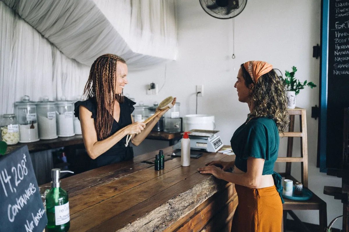 A local business owner listening to a customer across the front counter of a service shop
