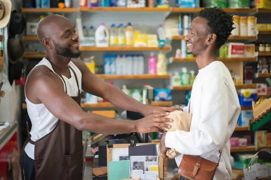 A local business owner listening to a customer across the front counter of a service shop